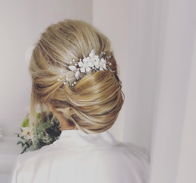Chica rubia con el penado con flores para una boda. vista de espaldas